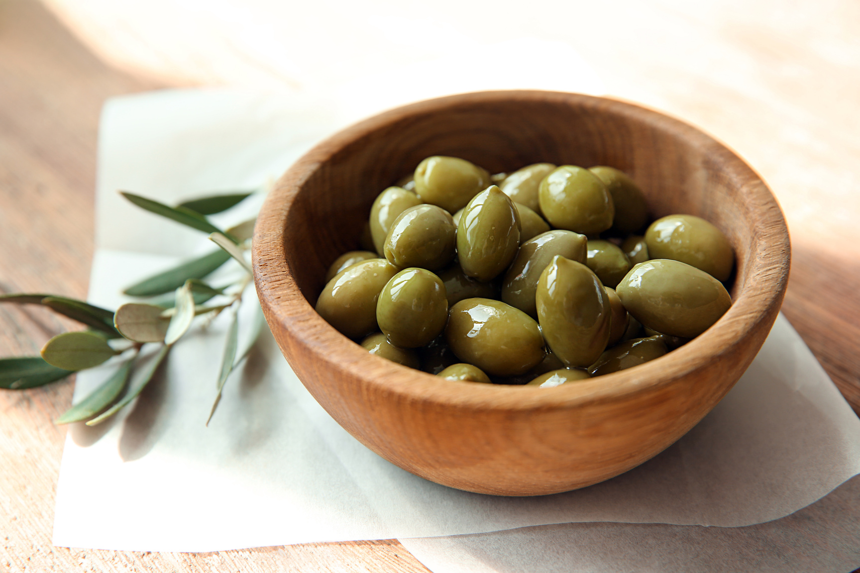 Bowl with Canned Olives on Wooden Table